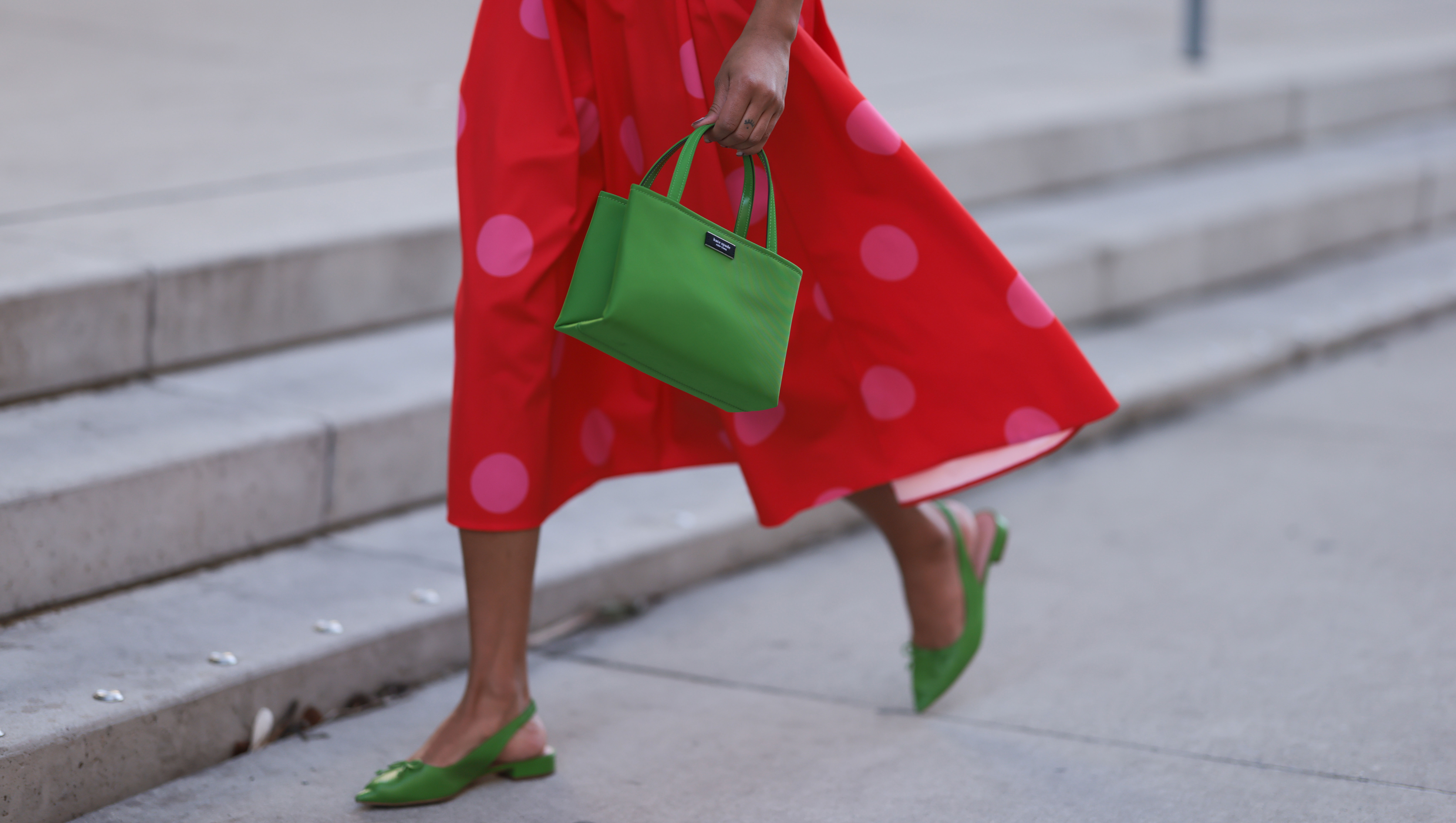 NEW YORK, NEW YORK - FEBRUARY 10: Olivia Joan seen wearing Kate Spade knit green top and cardigan, Kate Spade red long skirt with pink polka dot pattern, Kate Spate green leather bag and green leather mules before the Kate Spade presentation on February 10, 2023 in New York City. (Photo by Jeremy Moeller/Getty Images)